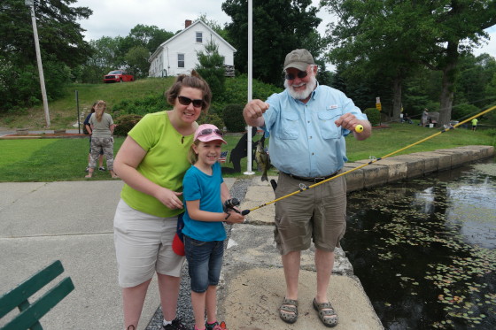 Eva catching a fish with Allison and Uncle Howard